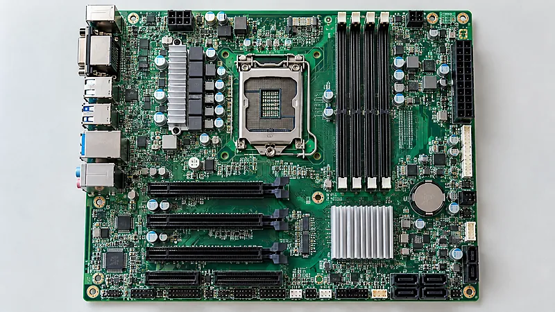 Top-down view of a computer motherboard showing the CPU socket, memory slots, expansion slots, and connectors.